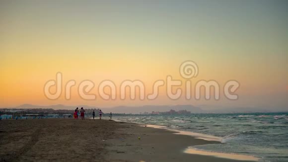 光波和人们在马尔瓦罗斯海滩的日落前游泳后聚集在一起西班牙巴伦西亚视频的预览图