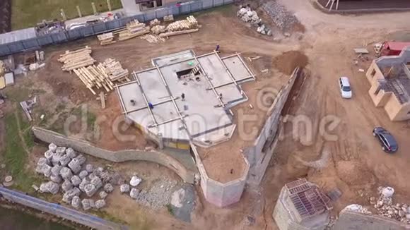 建筑物场地的鸟瞰图和工人为新房子或厂房附近的地基浇筑混凝土视频的预览图