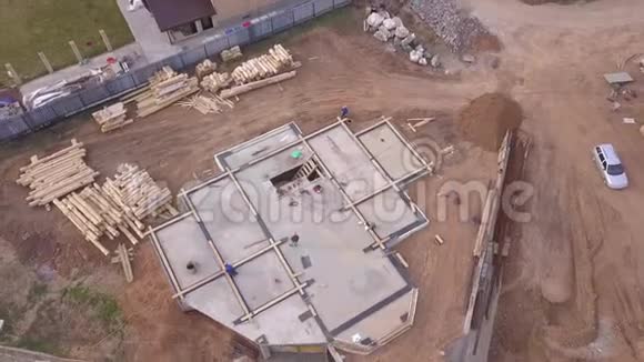 建筑物场地的鸟瞰图和工人为新房子或厂房附近的地基浇筑混凝土视频的预览图