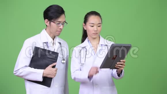 年轻的亚洲夫妇医生一起开会视频的预览图