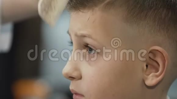 快关门理发师用梳子梳理发小男孩的发型设计视频的预览图