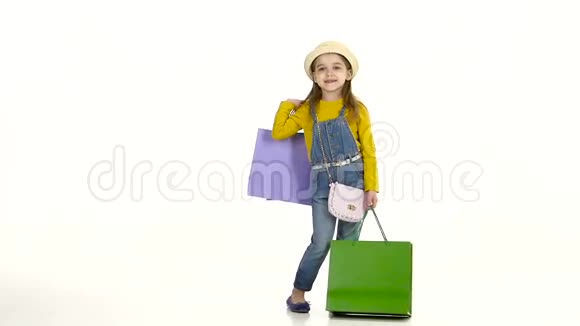 小女孩炫耀它的时尚购物白色背景慢动作视频的预览图