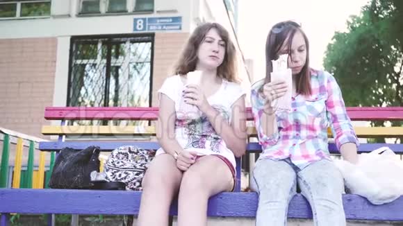 女孩们坐在长凳上吃沙瓦玛户外快餐的特写视频的预览图