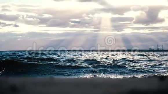 海浪在日落时的阳光背景下的风暴中肆虐缓慢的运动视频的预览图