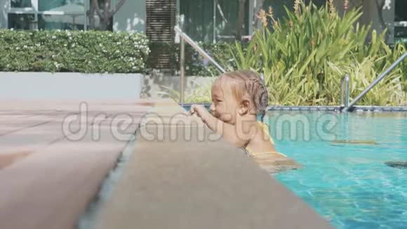 小可爱的女孩慢慢地爬出游泳池视频的预览图