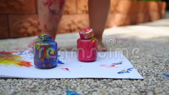 孩子们的腿在一张白纸上画一幅手指画蓝色红色和黄色儿童创造性发展视频的预览图