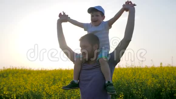 田野里幸福家庭的画像父亲和儿子在脖子上玩成花父亲和孩子被愚弄了视频的预览图