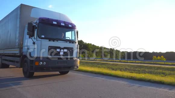 卡车在高速公路上行驶时镜头跟着卡车在乡间穿行背景是美丽的风景视频的预览图