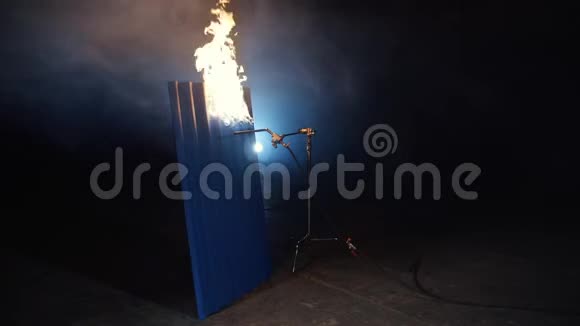 燃烧着蓝色的金属壁板和灰色的烟雾黑暗的背景视频的预览图