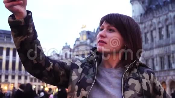 女游客在比利时布鲁塞尔的大广场上拍照慢动作多莉变焦效果视频的预览图