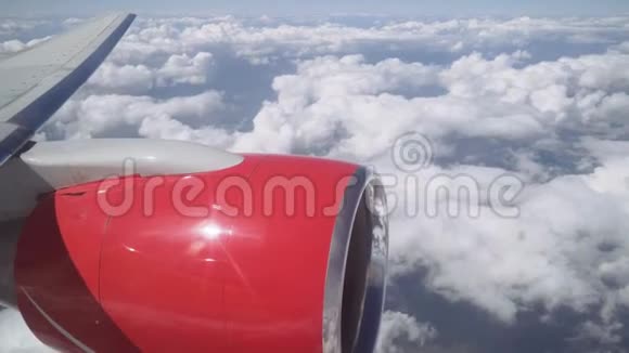 从舷窗到云层的景色从飞机的窗口看飞机的机翼与喷气发动机视频的预览图