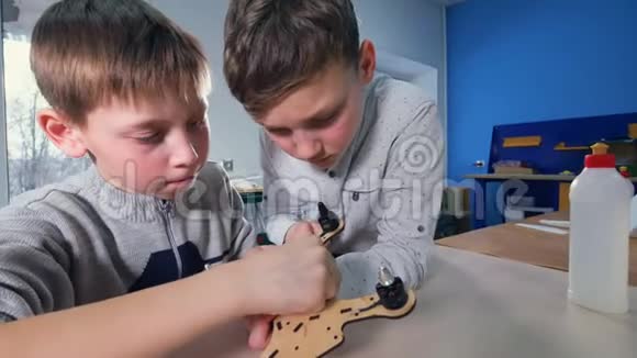 两个男孩正在整理他们的木制无人机模型视频的预览图