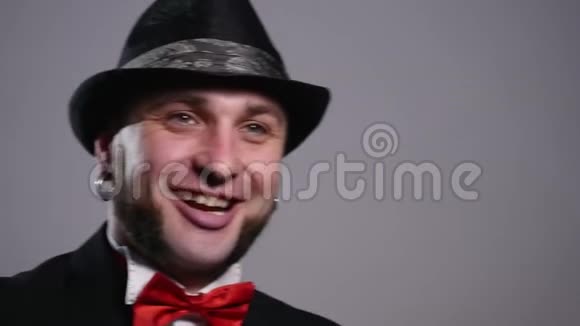 戴着灰色背景帽子的快乐胡子男人视频的预览图