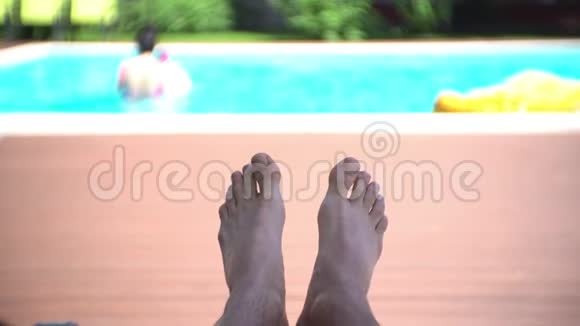 游泳池边白天睡觉的男腿视频的预览图