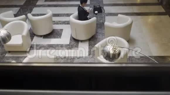 从电梯上拍摄时尚的女商人坐在酒店的大堂里视频的预览图