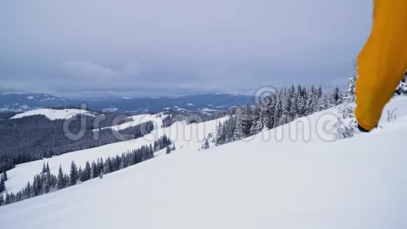 一个游客走过山上的雪视频的预览图
