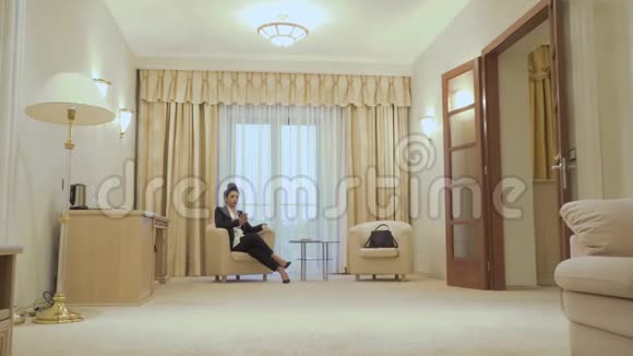 优雅的女商人在酒店客房靠近窗户的电话交谈视频的预览图