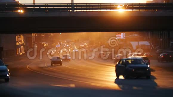 一个大城市汽车在桥下的道路上行驶交通拥挤日落视频的预览图