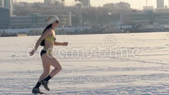 一个穿比基尼的女人在冰冻的河流上奔跑视频的预览图