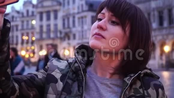 女游客在比利时布鲁塞尔的大广场上拍照慢动作多莉变焦效果视频的预览图
