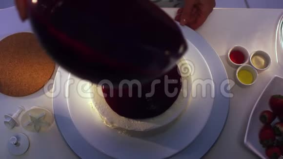 女人手旋转盘子上面放着白色的蛋糕和紫色的奶油视频的预览图