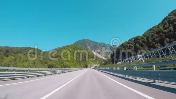 汽车行驶在铁路附近的高速公路上与蓝天和白种人的山脉相对场景索契克拉斯诺达尔地区视频的预览图
