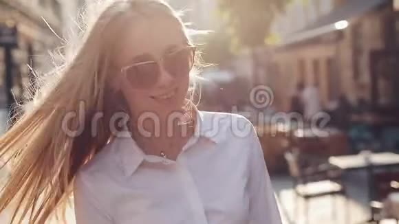 迷人的年轻女子一头华丽的棕色头发戴着时髦的太阳镜迷人的年轻女士正在城里奔波视频的预览图