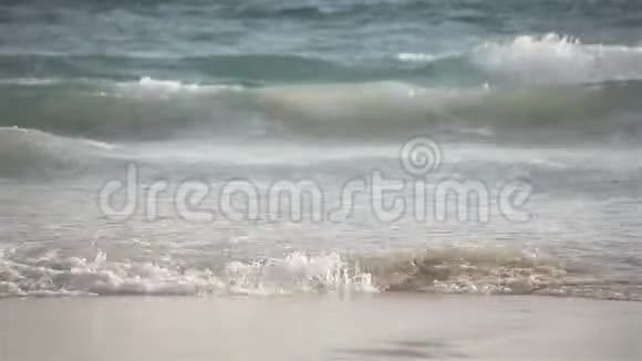 风和日丽的一天海浪拍打沙滩长焦特写视频的预览图