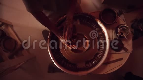陶工用托盘和手成型小泥板的车轮的俯视图视频的预览图