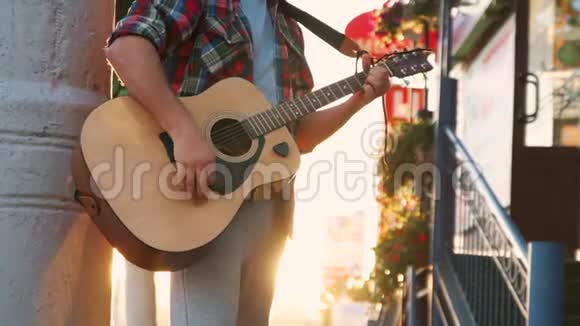 在日落时分穿着衬衫弹吉他的街头音乐家面目全非视频的预览图
