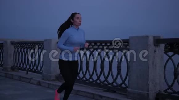 一个穿着运动服的年轻女孩在月光下的海滨慢跑2这名运动员从事体育运动视频的预览图