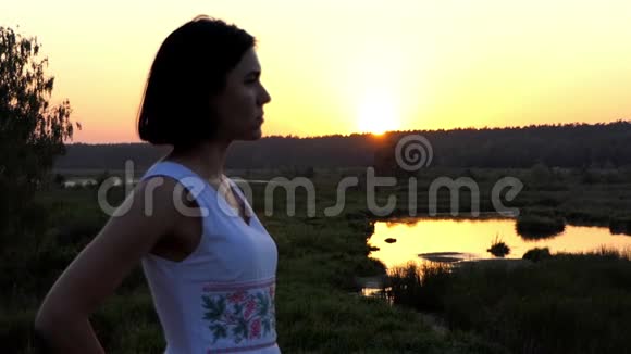 年轻的浪漫女人在美丽的日落中缓慢地亲吻视频的预览图