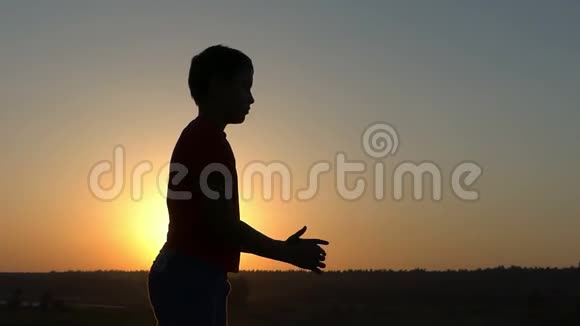 小男孩在日落时做身体锻炼动作慢视频的预览图