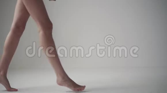 女性的腿女孩踮着脚在白色背景上赤脚走路视频的预览图