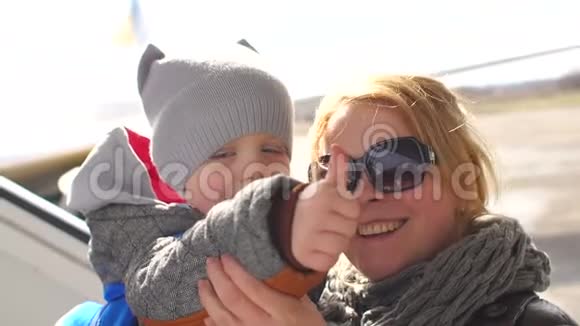妈妈和儿子在飞机背景上竖起大拇指视频的预览图
