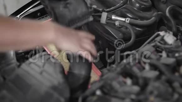 一名专业汽车修理工在汽车引擎盖下固定一部分固定汽车发动机的特写镜头视频的预览图