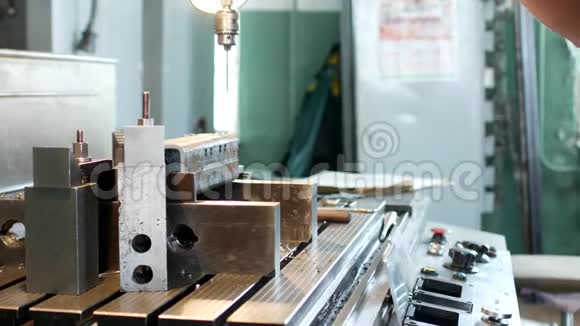 一个人专门为一个钻工准备一个金属工件以便在进一步钻加工视频的预览图