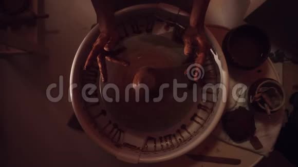 女人手正在做陶工她的车轮塑造长而薄的陶罐视频的预览图