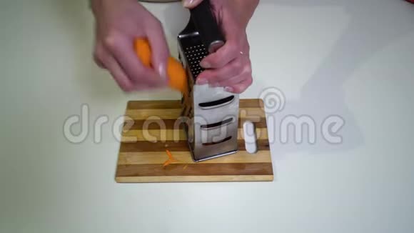 厨房特写镜头一个年轻的女人正在准备食物手的少女特写一个女人在金属磨盘上摩擦胡萝卜视频的预览图