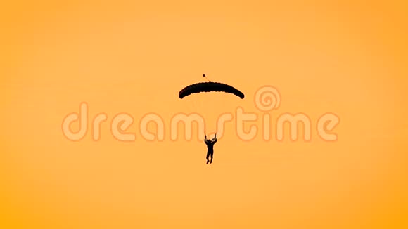 一个人在黄色的天空中滑翔伞的剪影日落时炽热的天空视频的预览图