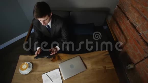 女商人在木桌上的咖啡馆里使用平板电脑顶部视图视频的预览图