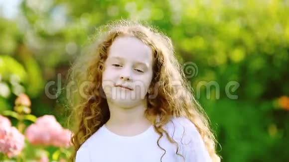 卷曲的女孩穿着一件白色的t恤正在微笑正在公园里抱着一朵向日葵视频的预览图