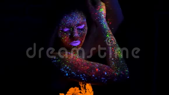 紫色头发与霓虹灯一起跳舞的美丽女人的肖像有荧光创意的模特女郎视频的预览图