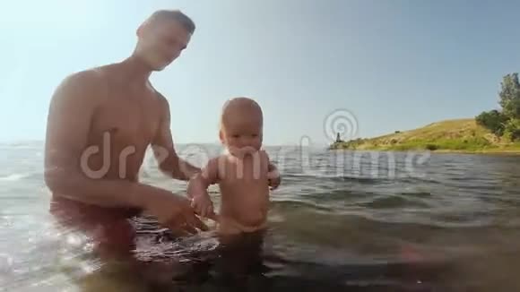 快乐的爸爸和宝宝在海里玩在水中锻炼视频的预览图