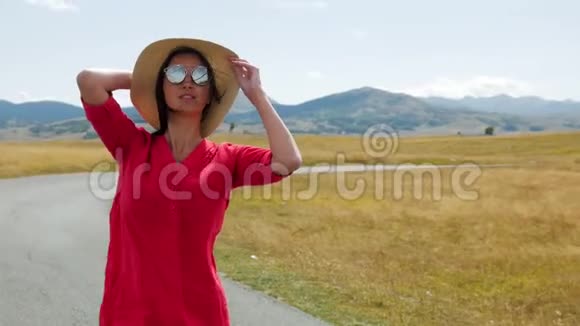 穿着红衣服的女孩站在秋天的田野里视频的预览图