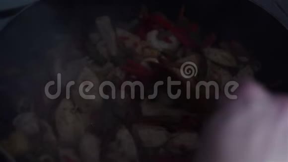 厨师把鸡肉和蔬菜混合在锅里视频的预览图