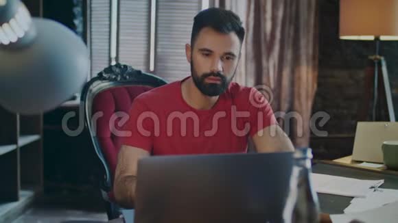 惊讶的男人在使用笔记本电脑时微笑商人用笔记本视频的预览图