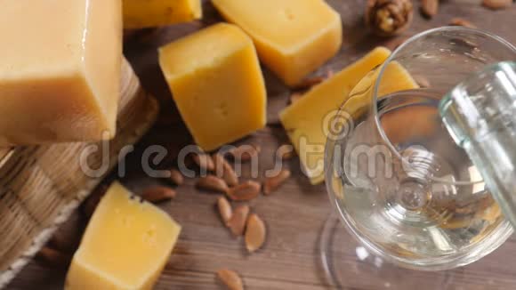 葡萄酒和奶酪食品艺术不同种类的硬奶酪在木制背景上装饰得很漂亮白葡萄酒正在视频的预览图