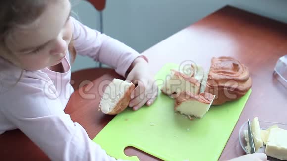 小女孩宝宝在一条面包上涂黄油视频的预览图