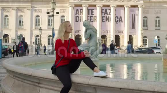 年轻有魅力的女人在里斯本的一个喷泉前放松视频的预览图